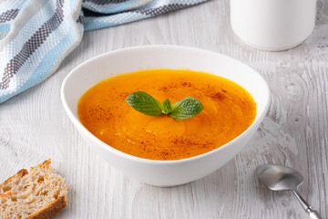 Pumpkin and carrot soup on white background