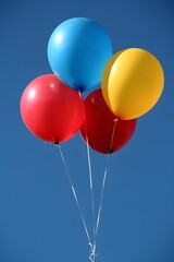 Four Colorful Balloons Floating In The Blue Sky