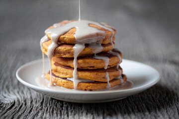Decadent Stack of Pumpkin Spice Pancakes dripping with Sweet Syrup on a rustic gray wood background
