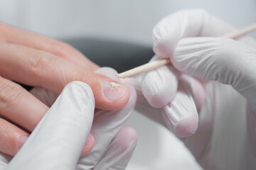 Japanese Manicure process for male nails in a beauty salon. Professional manicurist in gloves rubs nutrients into nails. Concept hand care technique with natural materials and compositions