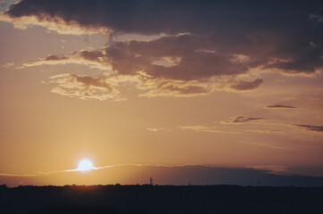 orange sunset in the clouds over the forest