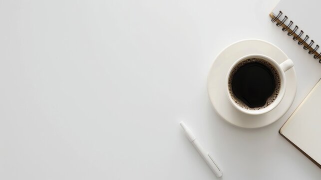 Minimal workplace setup with coffee and notepad on white background