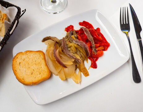 Festive and everyday vegetable dish of Catalan cuisine is escalibada. Large pieces of eggplant, pepper, onion baked in oven, complemented with salted anchovies and toasts.