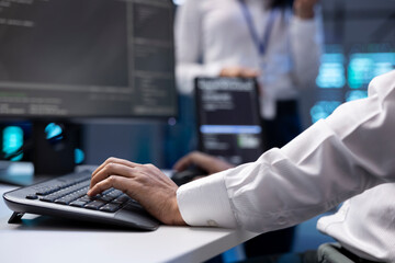 IT specialist ensuring server farm systems provide redundancy, automatic failover and rapid reconfiguration of clusters to minimize failure of individual machines, close up shot