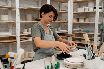 Building sides for clay products. Slab pottery. Creating ceramic products from flat sheets of clay. Using hands to model a form for a clay project.