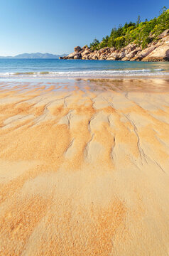 Picturesque golden sandy Alma Beach with granite boulders and turquoise water on Magnetic Island, Queensland, Australia.