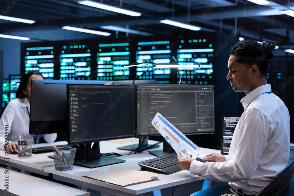 Poster engineer in data center doing yearly maintenance checkup to prolong hardware life span, looking over