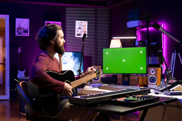 Beginner musician learning to tune his strings accords by watching tutorials online, twisting the...