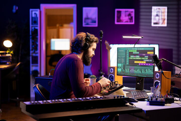 Audio producer twisting pre amp knobs on console to edit music, recording tunes with daw software...