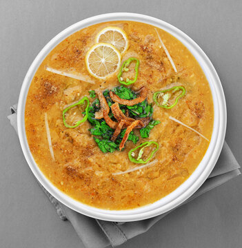 Spicy chicken haleem with fried onion, naan, roti served in dish isolated on background top view of indian spices and pakistani food
