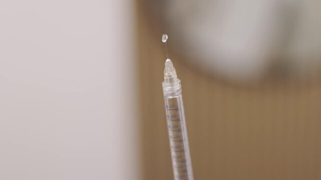 close up of a needle ejecting viscous fluid