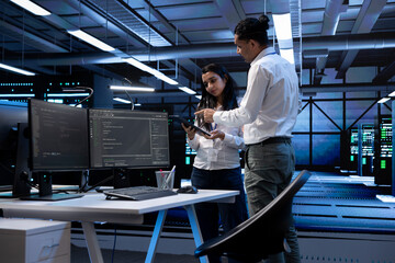 Tablet used by team of programmers in server room to find network issues affecting supercomputer...