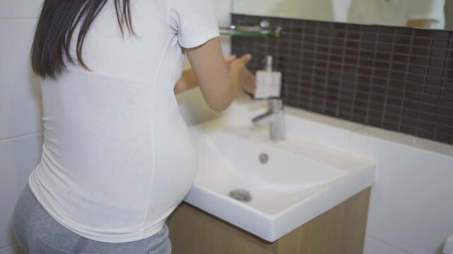 A portrait of happy Asian pregnant woman in toilet,  bathroom or restroom with basin. Having a baby. Family people lifestyle. Mom love.