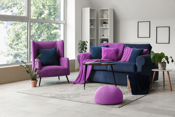 Modern interior of living room with stylish sofa and armchair