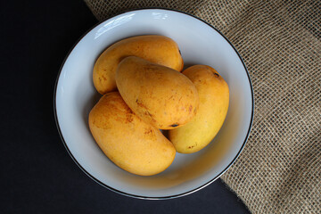 Bowl of mangoes on dark background