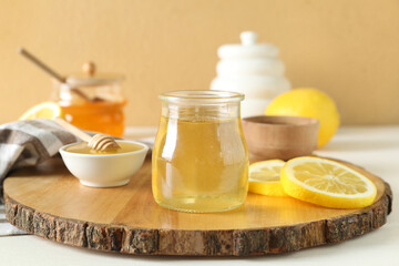 Jar of sweet honey with lemon on table