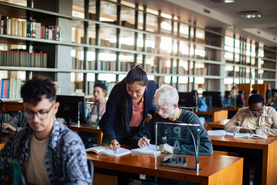 Female professor assisting student in library study session