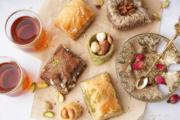 Tasty baklava and glasses of Turkish tea on light background