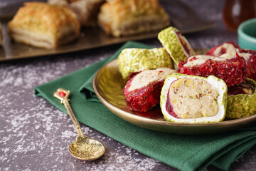 Plate with tasty Turkish Delight on grunge background, closeup