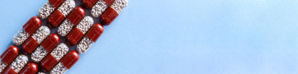 Two-color pills with enzyme preparation to improve digestion. Medical concept of taking medication....