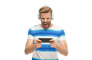 Music and game. Man gamer in headphones play video game online with smartphone. Man using smartphone for gaming isolated in white. Play game on smartphone. Gaming lifestyle. Angry gamer