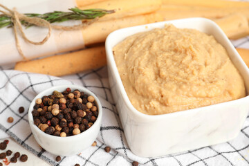 Bowl with tasty hummus on table, closeup