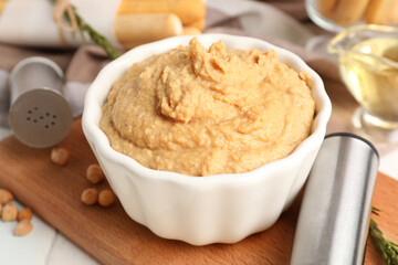 Bowl with tasty hummus on table, closeup