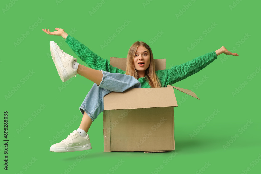 Sticker cheerful young woman sitting in cardboard box on green background. moving house concept