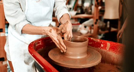 Hands, pottery wheel and person with talent, clay and creativity in workshop, masterclass or tools. Closeup, entrepreneur or instructor with equipment, designer or artist with hobby or small business
