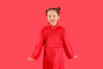 Cute little Asian girl on red background. Chinese New Year celebration