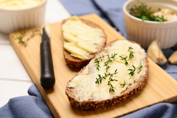 Board of bread slices with fresh butter on table
