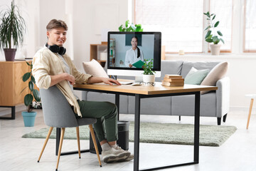Male student studying with online teacher at home