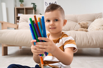 Cute little boy drawing with felt-tip pens at home, closeup