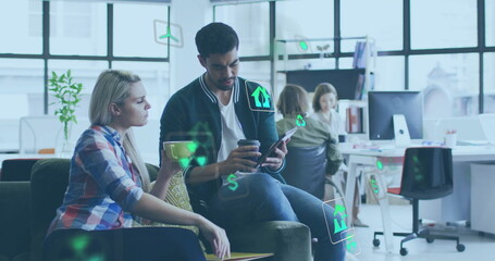 Image of ecology icons over diverse colleagues using tablet and discussing work in office