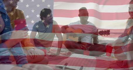 Image of american flag over happy diverse friends playing guitar and singing on sunny beach