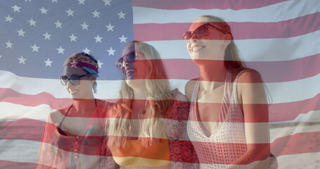 Image of american flag over happy happy caucasian female friends walking on sunny beach