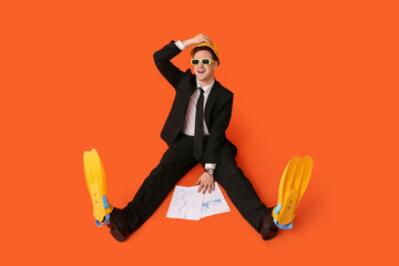 Office worker in sunglasses and flippers with papers dreaming about vacation on orange background