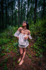 barefoot brunette in a white sundress into the woods.