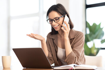 Informal Call. Happy young woman in glasses calling her friend, talking and asking about something,...