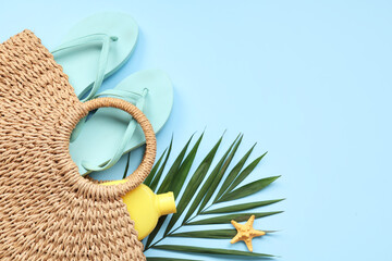 Beautiful composition with beach accessories and sunscreen on blue background