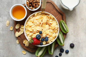 Wooden tray, bowl with cornflakes and berries on grunge background, closeup