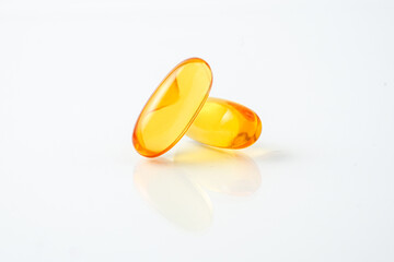 Two capsules fish oil,  Softgel Omega 3, Vitamin D,E,A. Supplement capsules isolated white...