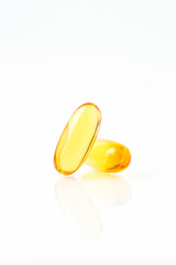 Two capsules fish oil,  Softgel Omega 3, Vitamin D,E,A. Supplement capsules isolated white...