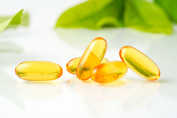 Pile of yellow softgel medical pills, supplement vitamin, isolated over the white background