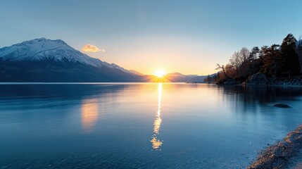 Fototapeta premium A beautiful sunrise over a tranquil lake with mountain reflections, capturing the serene and peaceful essence of the natural landscape in perfect harmony.