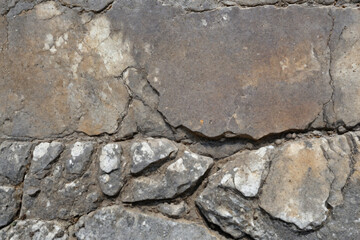 Fototapeta premium Weathered stone grunge texture with prominent cracks and natural erosion patterns
