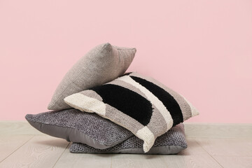 Stack of cushions near pink wall in room