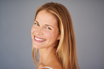 Portrait, woman and happy in studio with mockup for skincare, collagen and natural makeup. Female person, face smile and dermatology with space, beauty and facial glow isolated on gray background