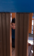 A joyous child peeking between playground bars on a sunny day, embodying childhood innocence