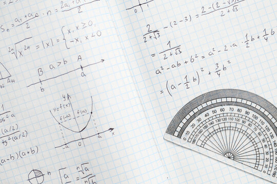 Copybook with handwritten maths formulas and semicircular protractor as background, closeup